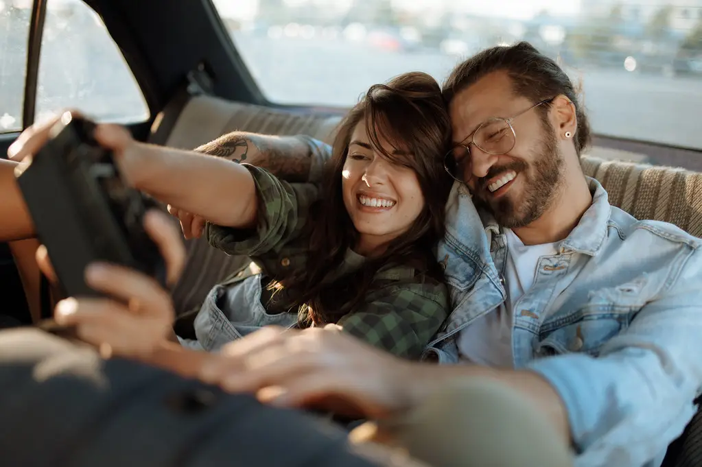 Happy couple booking a car rental with Zafir Muscat